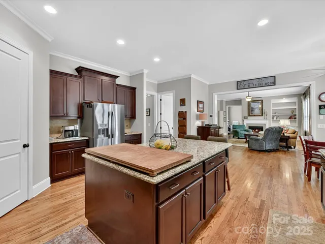 a kitchen with stainless steel appliances granite countertop table chairs sink refrigerator and stove
