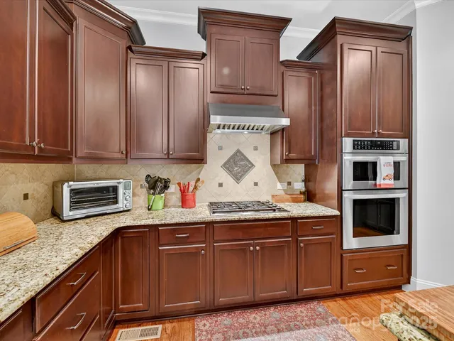 a kitchen with stainless steel appliances granite countertop a stove and cabinets