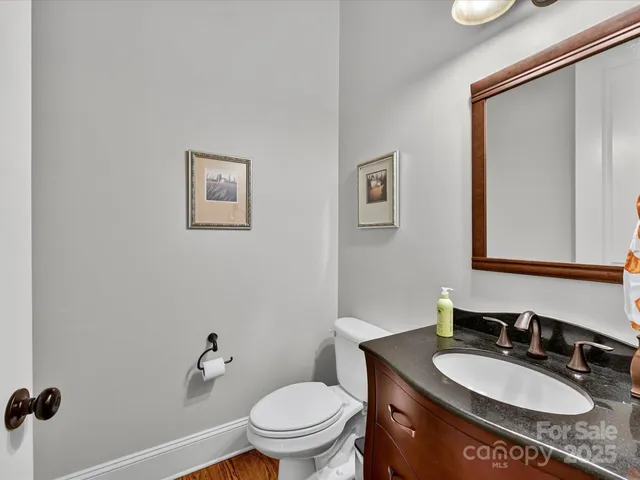 a bathroom with a granite countertop toilet a sink and mirror