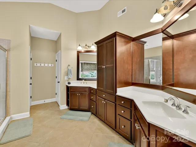 a spacious bathroom with a tub sink and mirror