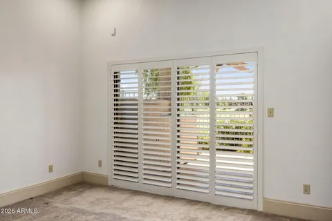 a view of a room that has a window and a ceiling fan