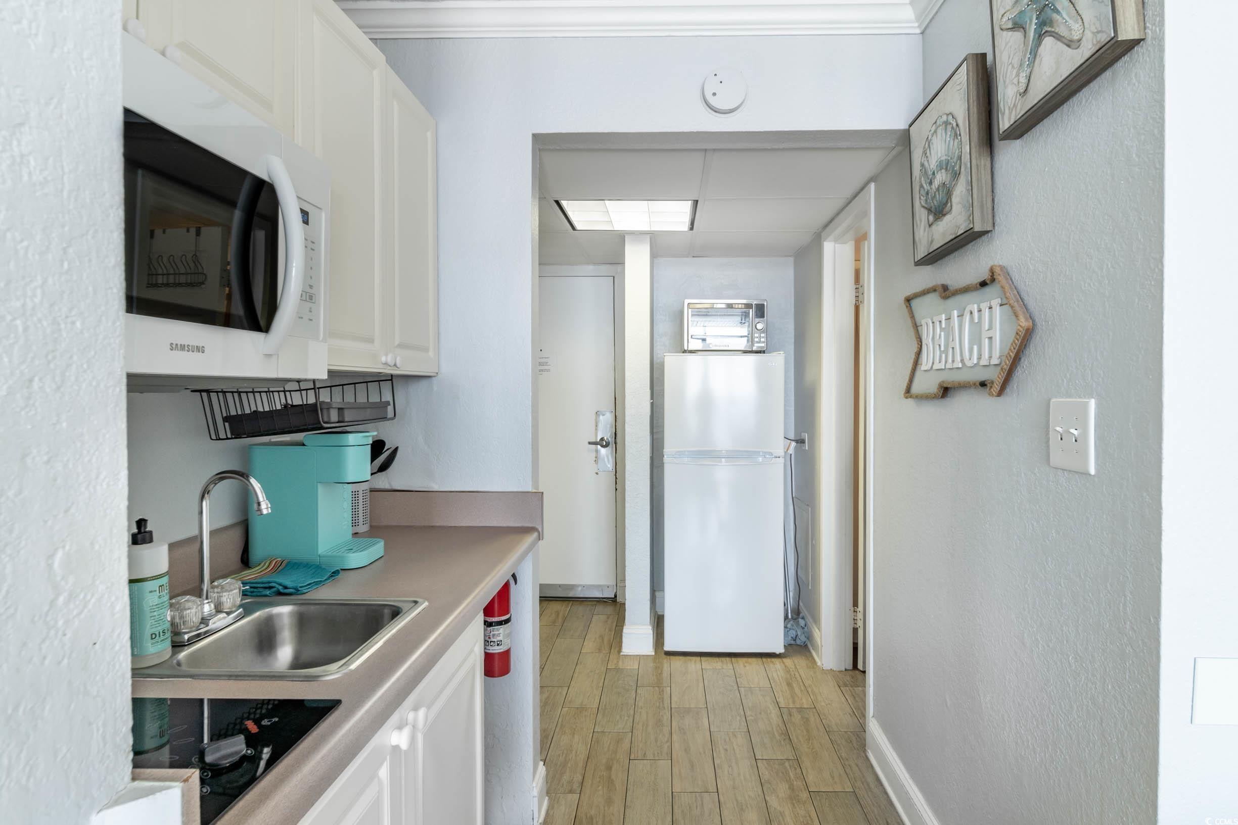 201 74th Avenue North, Unit 2532 Myrtle Beach, SC 29572 - Photo 14 of 39 Kitchen with sink, white appliances, light hardwoo