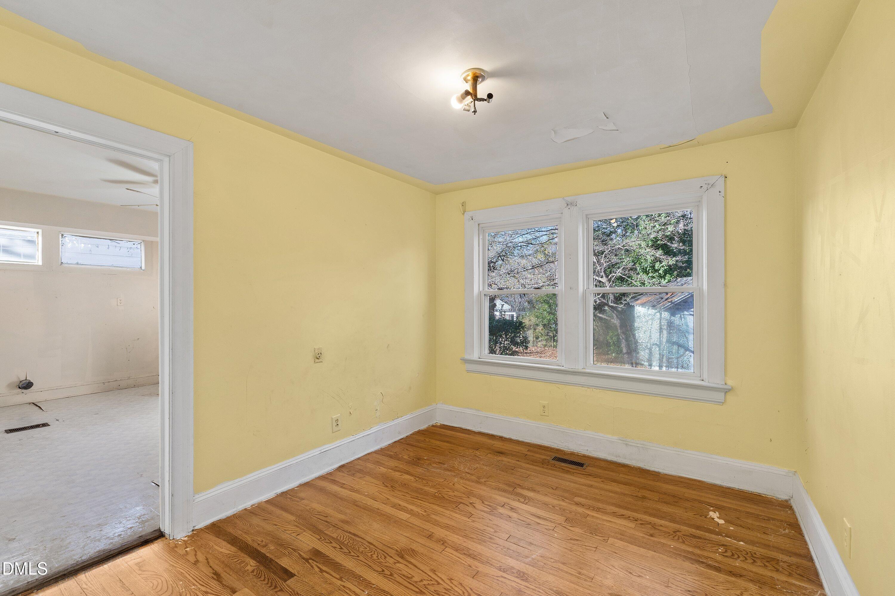 1205 Watauga Street Raleigh, NC 27604 - Photo 12 of 26 a view of an empty room with a window and wooden floor