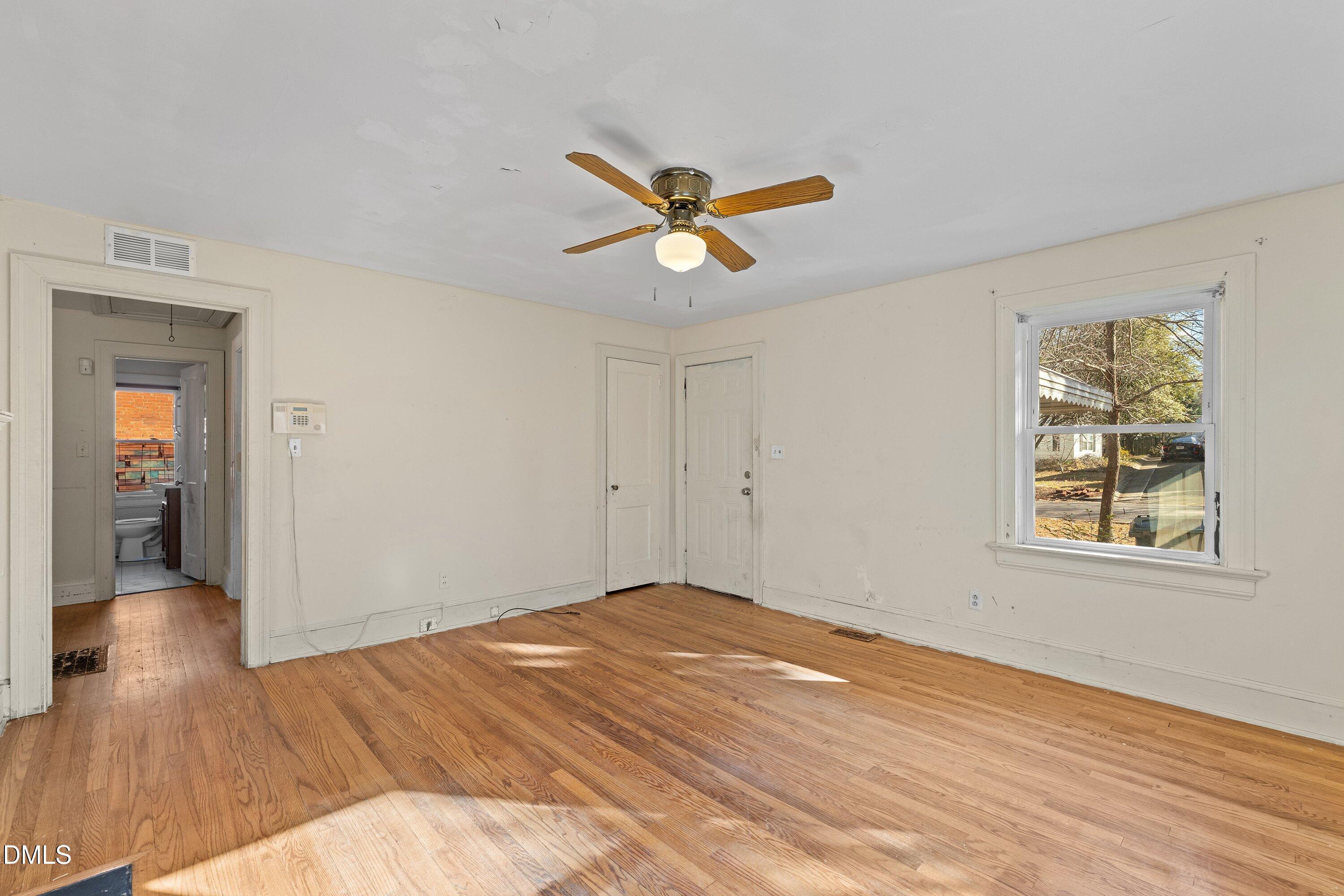 1205 Watauga Street Raleigh, NC 27604 - Photo 6 of 26 a view of a room with wooden floor and a ceiling fan