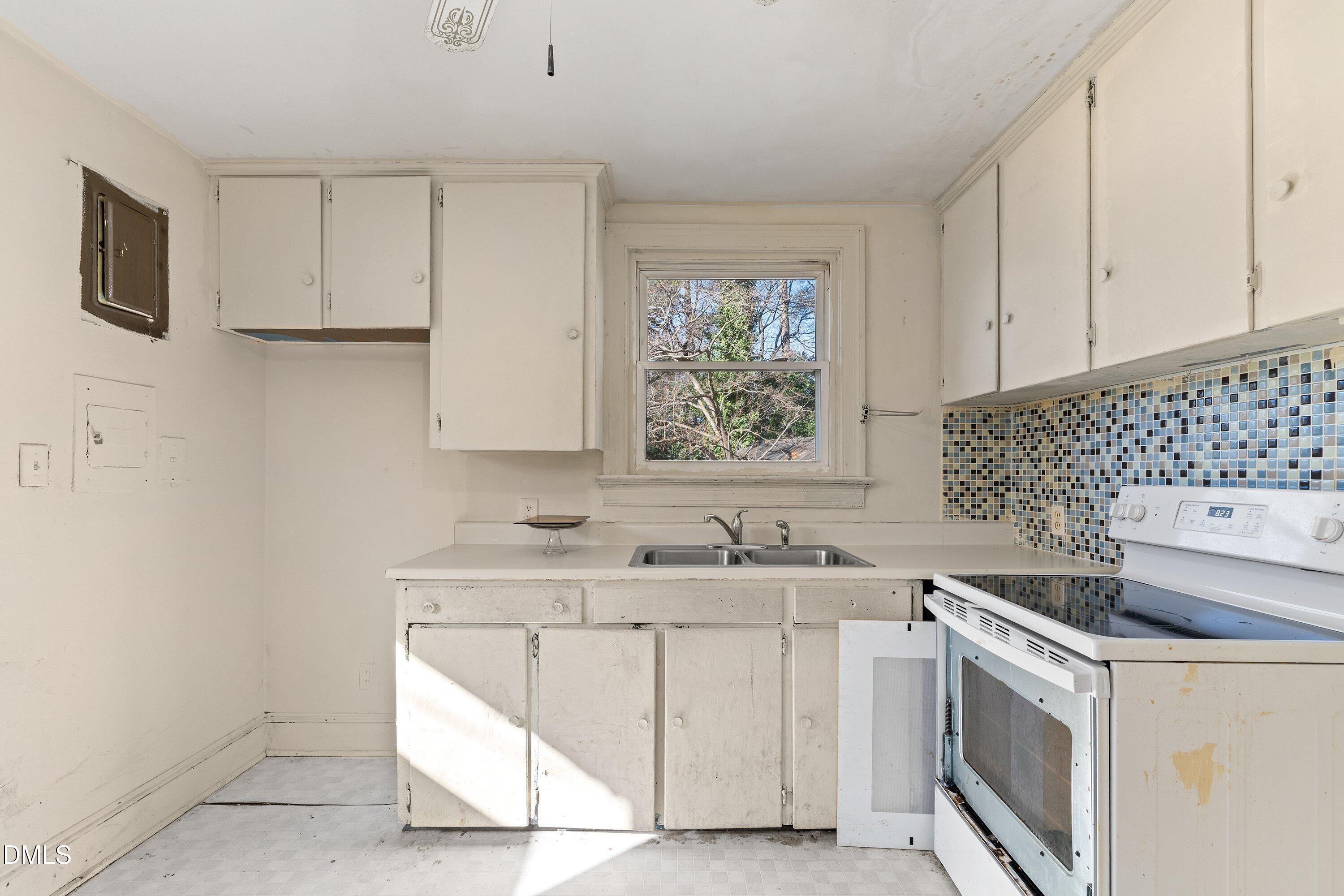 1205 Watauga Street Raleigh, NC 27604 - Photo 8 of 26 a kitchen with a sink stove and cabinets