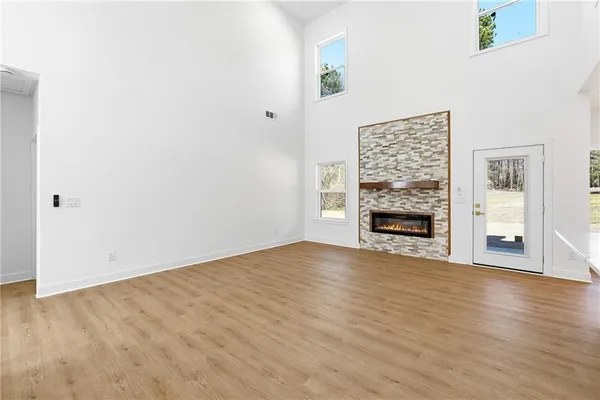 a view of empty room with wooden floor and fireplace