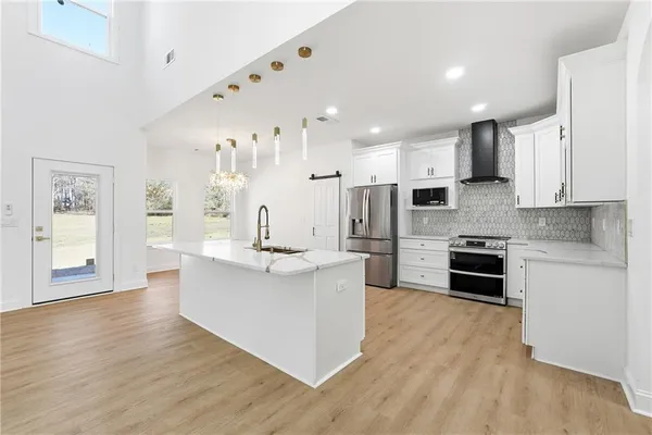 a large kitchen with stainless steel appliances lots of counter space and a sink