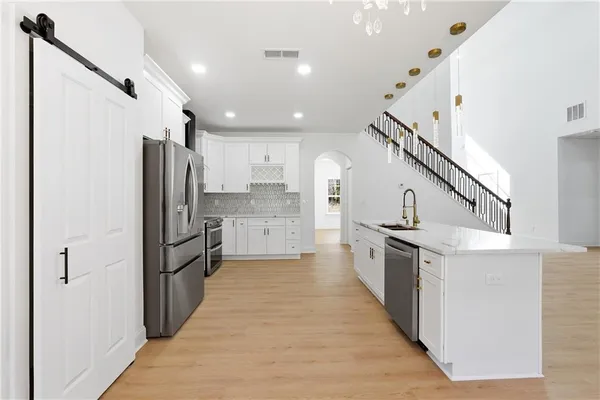 a kitchen with stainless steel appliances a refrigerator and a stove top oven