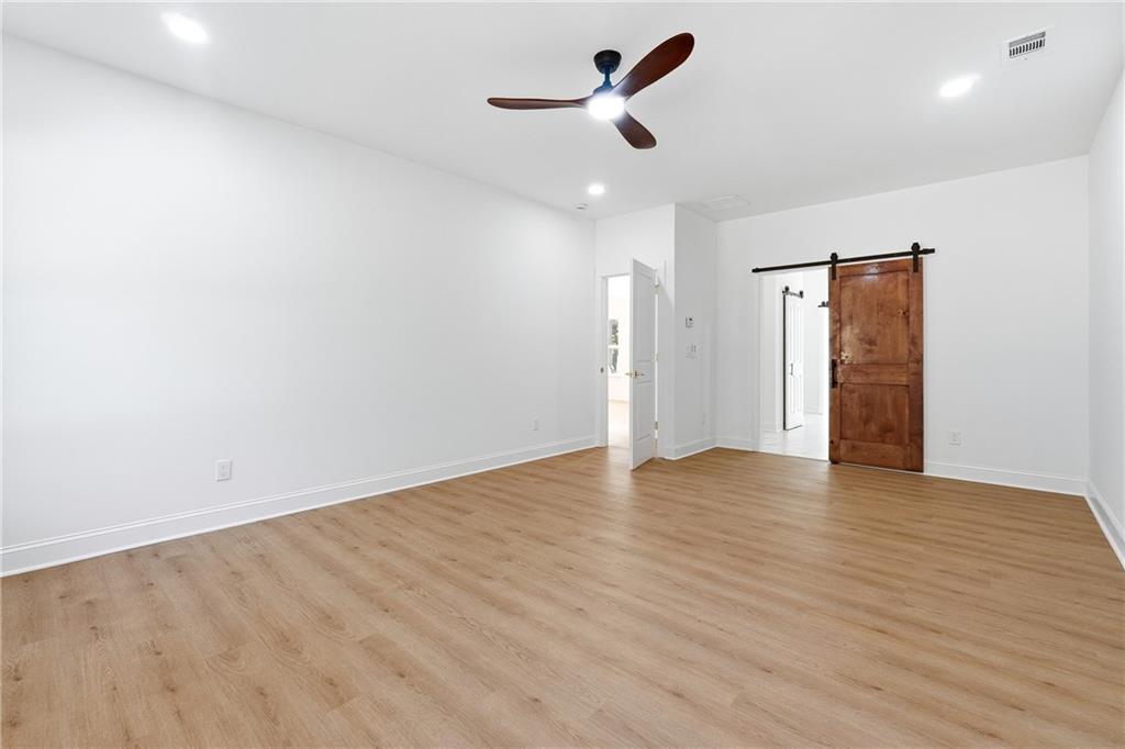 644 Hampton Road Hampton, GA 30228 - Photo 22 of 40 an empty room with wooden floor and windows