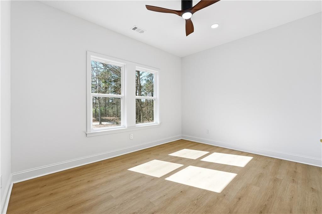 644 Hampton Road Hampton, GA 30228 - Photo 33 of 40 an empty room with wooden floor fan and windows