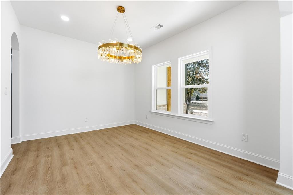 644 Hampton Road Hampton, GA 30228 - Photo 7 of 40 an empty room with wooden floor chandelier and window
