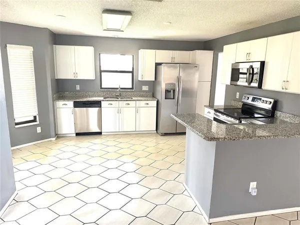 a kitchen with stainless steel appliances a refrigerator sink and microwave