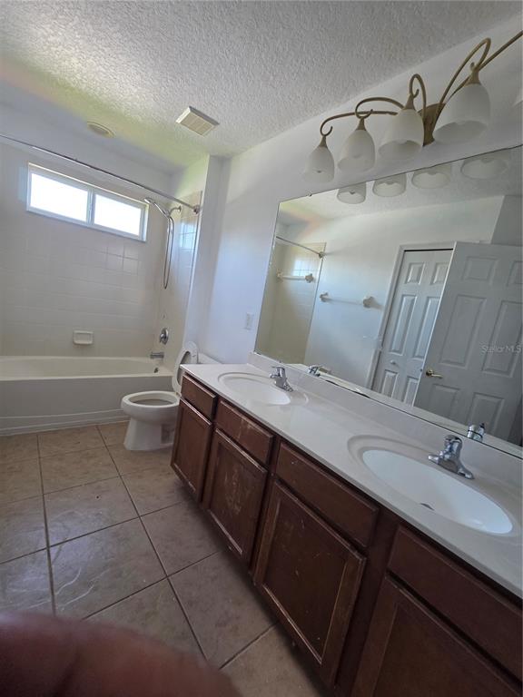 2400 Tybee Road St. Cloud, FL 34769 - Photo 11 of 15 a bathroom with a double vanity sink toilet and a bathtub