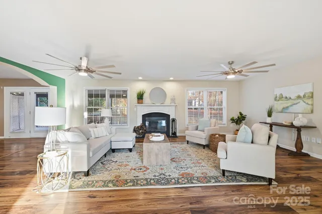 a living room with furniture a fireplace and wooden floor