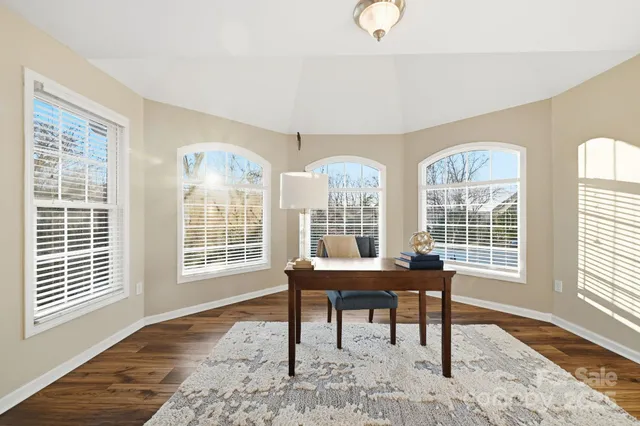 a view of a work space with wooden floor and a floor to ceiling window