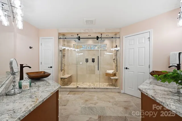 a bathroom with a granite countertop sink a toilet and shower