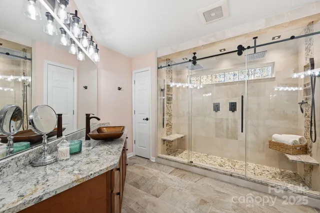 a bathroom with a granite countertop sink mirror and shower