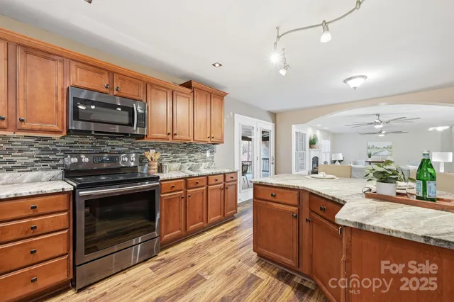 a kitchen with granite countertop cabinets stainless steel appliances and a counter space