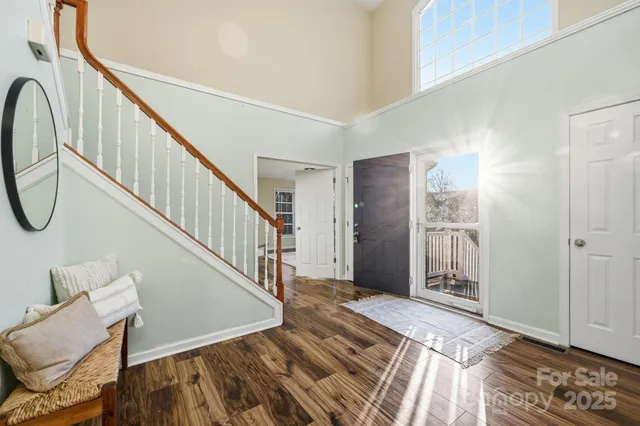 a view of a livingroom with wooden floor and stairs