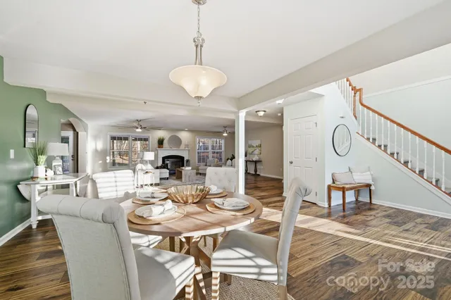 a dining room with wooden floor a chandelier a wooden table and chairs