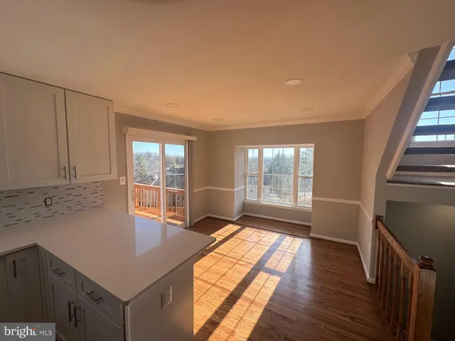 a hallway with a large window and wooden floor