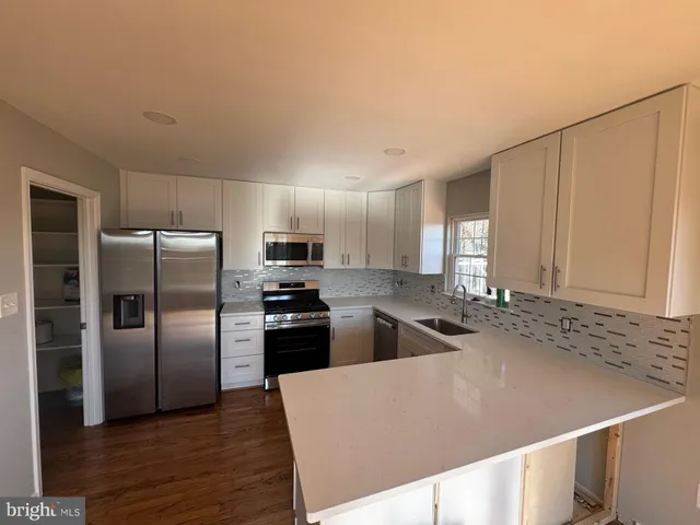 a kitchen with stainless steel appliances a refrigerator sink and microwave
