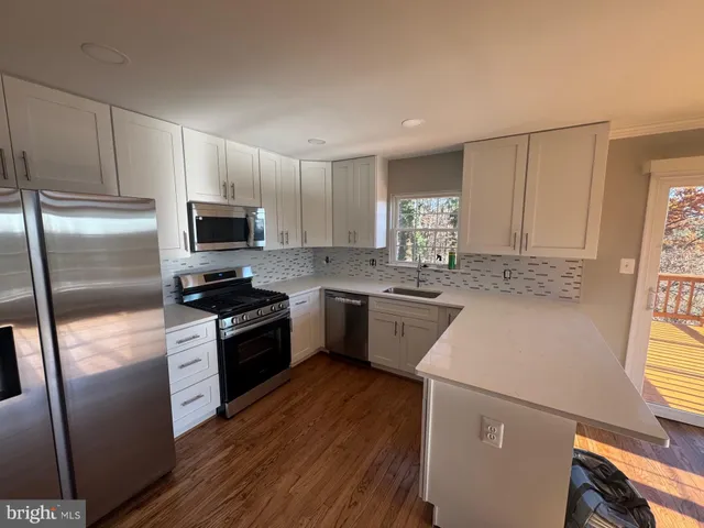 a kitchen with a sink a microwave a refrigerator and cabinets