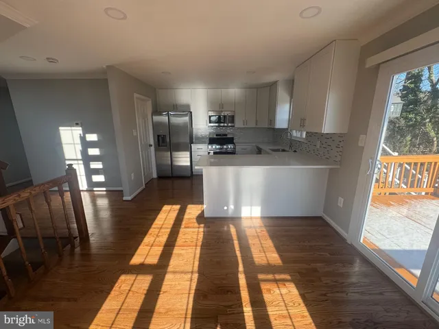 a large kitchen with stainless steel appliances granite countertop a refrigerator and a stove top oven