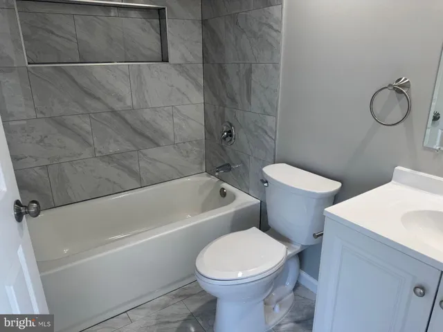 a white toilet sitting next to a bath tub