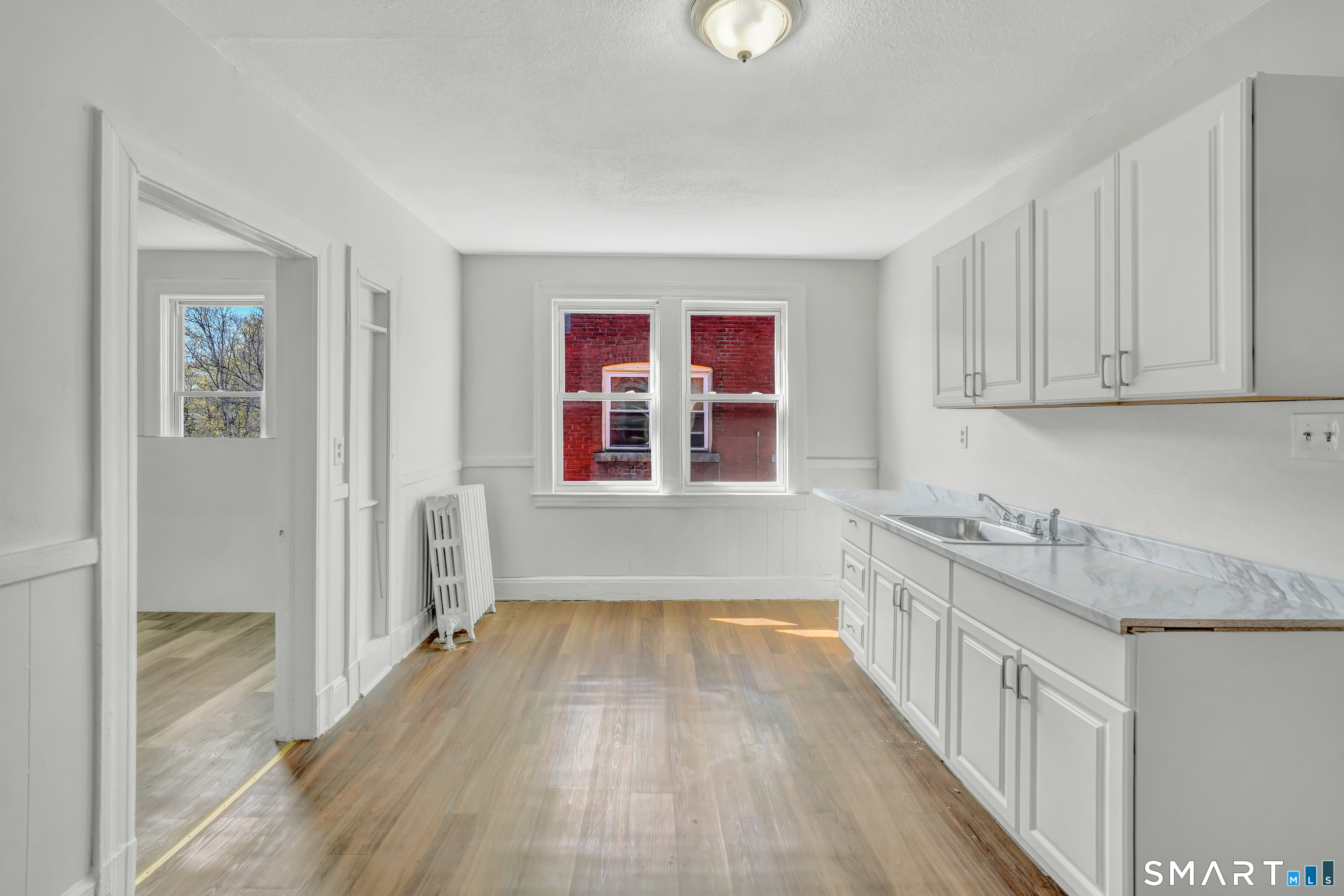 22 Harper Street, Unit 3 Hartford, CT 06112 - Photo 1 of 5 a kitchen with granite countertop a sink and wooden cabinets