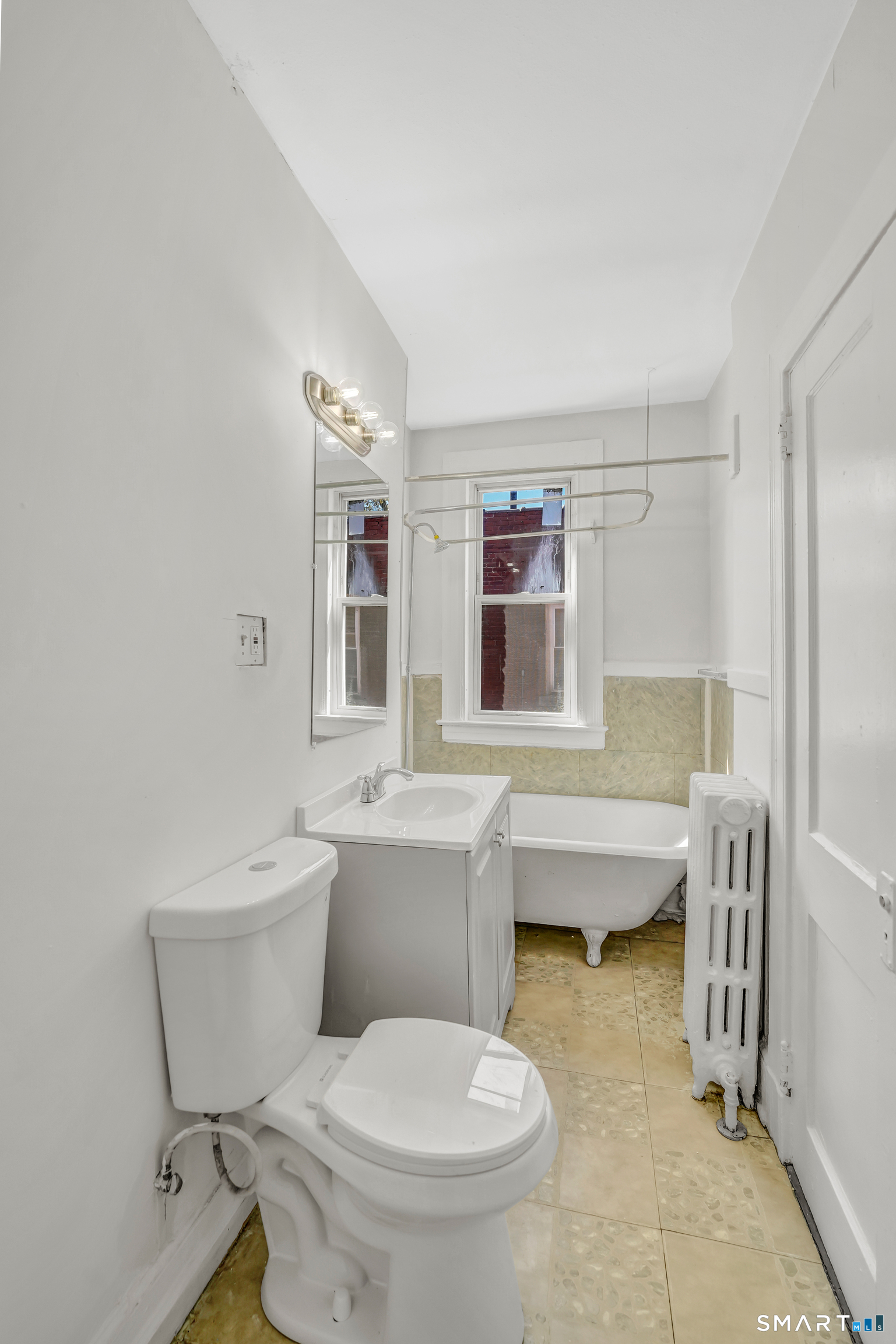 22 Harper Street, Unit 3 Hartford, CT 06112 - Photo 2 of 5 a bathroom with a toilet sink and mirror