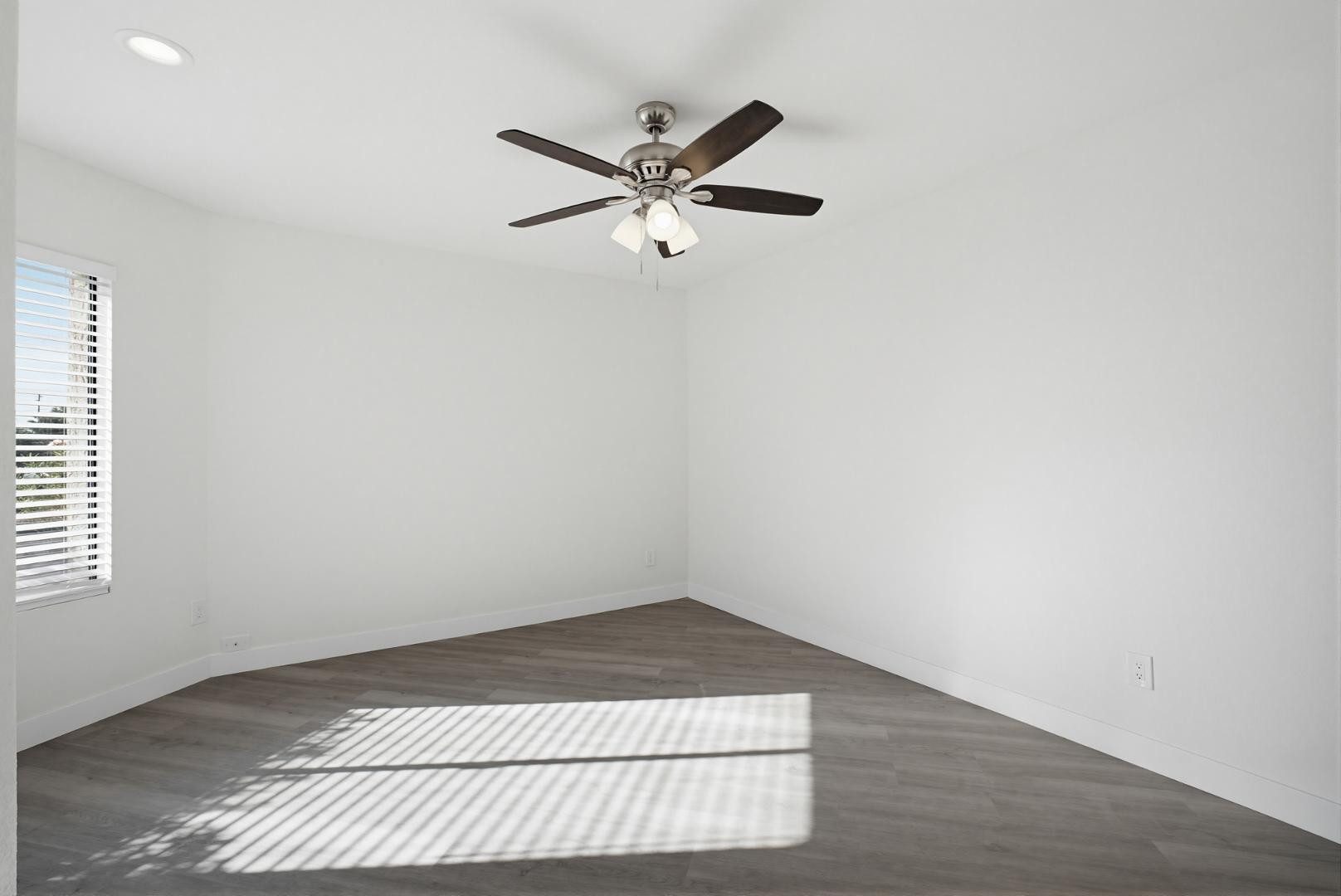 316 East Turquoise Avenue Phoenix, AZ 85020 - Photo 19 of 27 an empty room with wooden floor a ceiling fan and windows