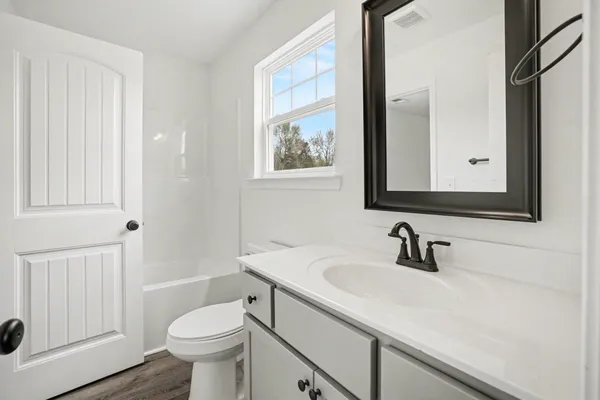 a bathroom with a sink a toilet and a mirror