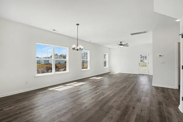 a view of empty room with wooden floor and window