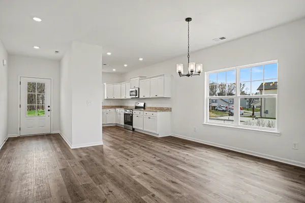 a view of a kitchen with kitchen island wooden floor appliances and window