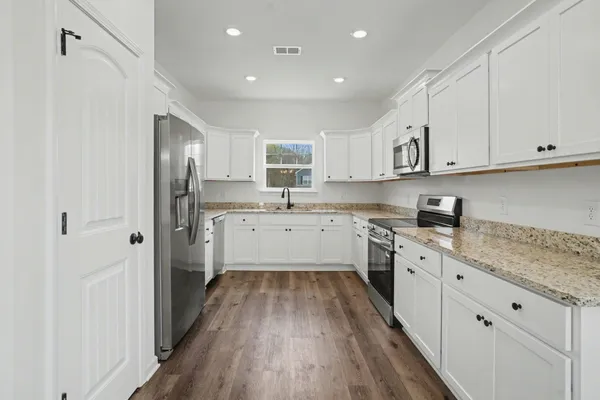 a kitchen with cabinets oven a sink and a counter space