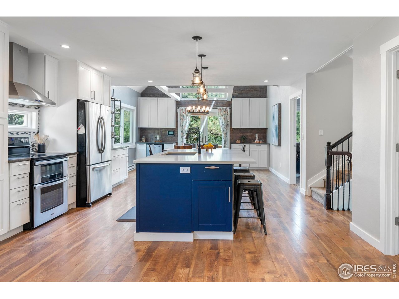6521 Olde Stage Road Boulder, CO 80302 - Photo 8 of 47 a kitchen with stainless steel appliances granite countertop a refrigerator oven a sink dishwasher and white cabinets with wooden floor