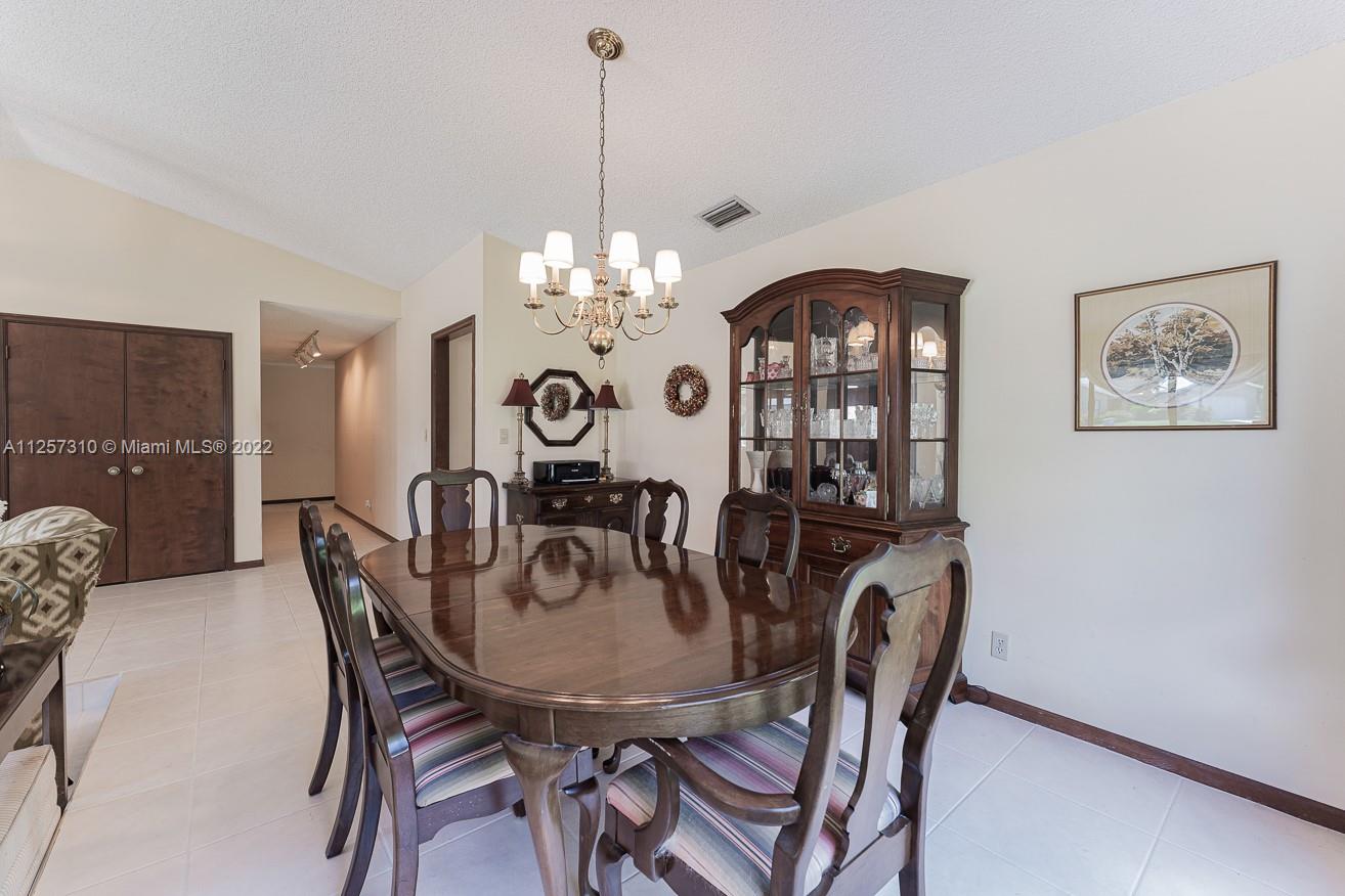 21947 Holly Tree Way Boca Raton, FL 33428 - Photo 8 of 43 a view of a dining room with furniture and chandelier