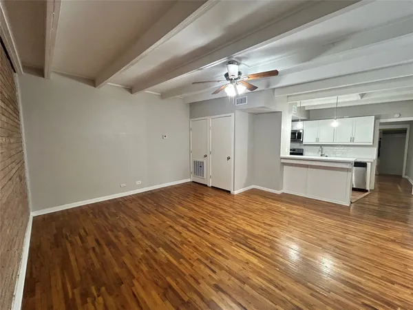 a view of a kitchen with a ceiling fan hardwood floor and a kitchen