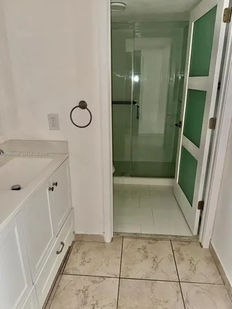 a bathroom with a granite countertop sink a mirror and shower