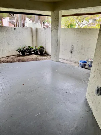 a view of a refrigerator in kitchen and an empty room