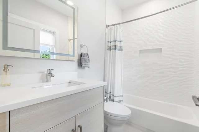 a bathroom with a double vanity sink toilet and shower