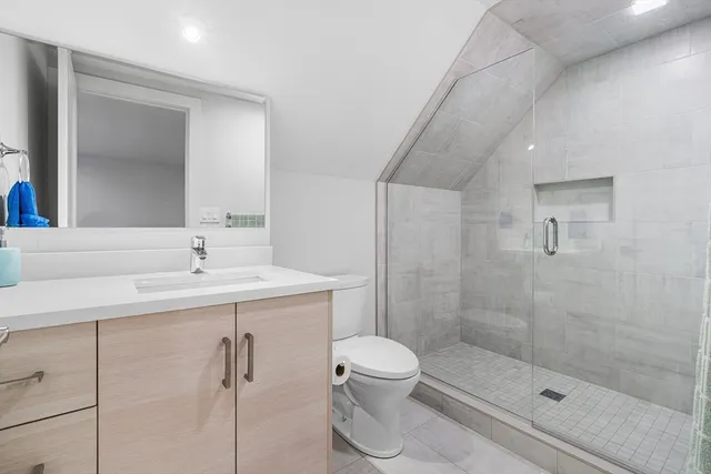 a bathroom with a sink a toilet and shower