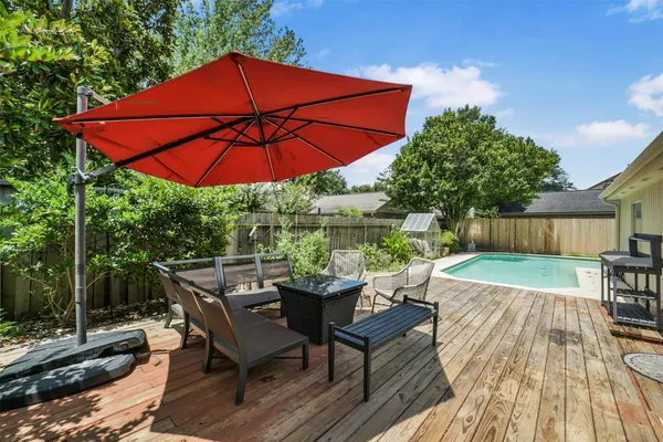 a patio with wooden floor a yard a table and chairs