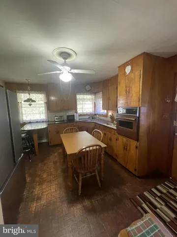 a kitchen with a sink a stove a refrigerator dining table and chairs