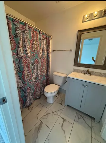 a bathroom with a toilet sink and mirror