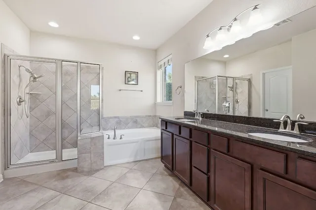 a spacious bathroom with a large tub shower and sink