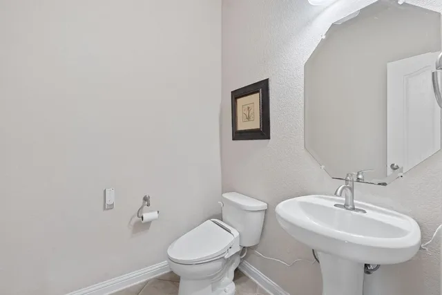 a bathroom with a sink toilet and a mirror