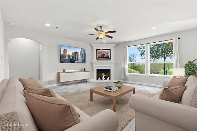 a living room with furniture a fireplace and a large window
