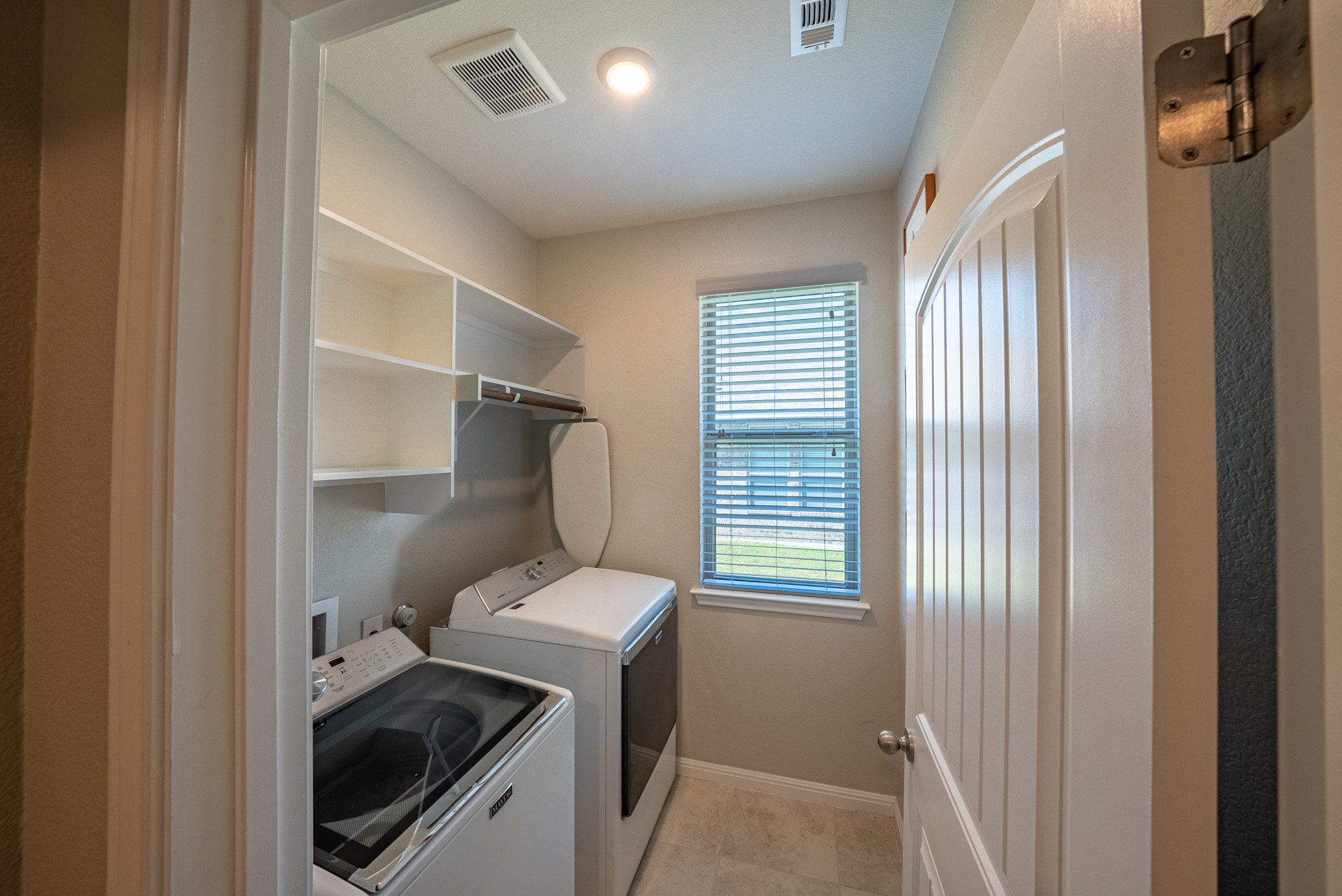 2508 Hat Bender Loop Round Rock, TX 78664 - Photo 19 of 22 Dedicated laundry room featuring built-in shelving, a window with blinds, and tile flooring